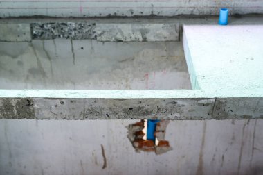 Ev tadilatı sırasındaki beton temelin ayrıntıları. İnşaat sahasında tesisat boru tesisatı kurulumu ve ev inşaatı için zemin yapısı onarımı görülüyor.