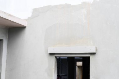 Ev yenileme projesi sırasında dış duvarda yeni bir alçı kaplaması. Ev geliştirmesi, konut inşaatının ilerleme ve inşaat aşamasını gösteriyor