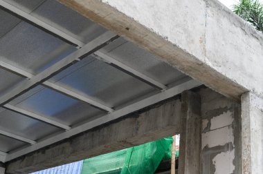 Mimari detay sağlam beton kiriş destekleyici çatı gösteriyor dayanıklı metal levha malzeme ve hafif köpük yalıtımı bina inşaatı sırasında hava koruma sağlar