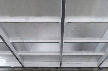 Sert metal kirişler tavan katmanı için temel bir yapı sağlar. Altında koruyucu köpük ile yalıtılmıştır. Güvenli güç ve termal verimlilik hissi verir.