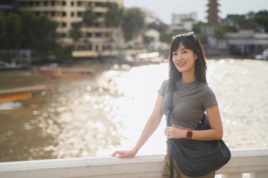 Güneydoğu Asyalı kadın blogcu ve dünya turizmi ile ilgili mutlu solo yazılar. Akıllı telefonlu kaşif, Bangkok, Tayland 'daki Chao Phraya Nehri' nde yerel kültür deneyiminin tadını çıkarıyor. Asya kavramı