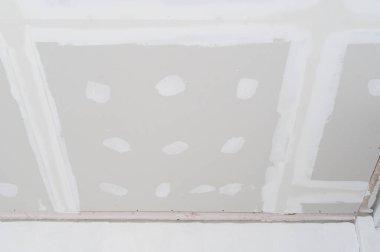 Alçıtaşı tavanı iç yenileme düz kenarlar gösteriyor. Elektrik kablosu alçıya alınıyor. İlerleme kaydetmek için heyecanlı bir son.