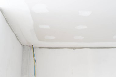 Alçıtaşı tavanı pürüzsüz kenarlar iç yenileme elektrik tel sıva inşaat projesinin tamamlanmamış beyaz yüzey odası köşeleri beklentisinin işlevsel olduğunu gösteriyor