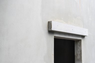 Ev yenileme projesi sırasında en az beyaz duvar bir açıklığın üzerinde beton kaplama olduğunu gösteriyor. Bitmemiş alçı yüzeyi ham ve huzurlu mimari hisler veriyor.