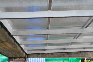 İnşaat manzarası termal panelleri destekleyen metal kirişleri gösteriyor. Çatı tavanı yapısı için enerji verimliliği sağlayan hafif köpük tabakaları doldurur
