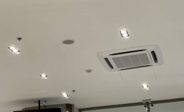 Havalandırma ve soğutma için modern klima sistemi olan beyaz tavan. Işıklandırma teknolojisi olan bir iç mekan. Bir ofis için temiz ve rahat bir ortam