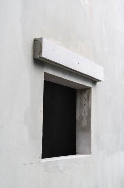 Tadilat sırasında modern evin katı beton duvarı. Boş kara pencere açılışı minimalist ve vahşi mimari detayları gösteriyor.