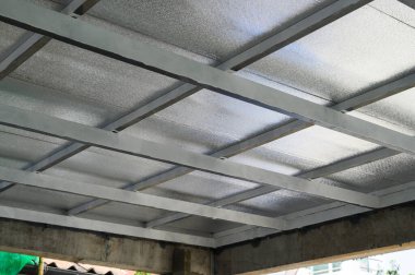 Gri metal kirişler, büyük levha panellerini destekleyen sağlam bir çerçeve oluşturur. Muhtemelen yalıtım için pu köpüğü içerir.