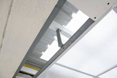 Modern evdeki tavan tadilatının titiz ayrıntıları. askıya alınan metal çerçeve, yeni inşaat projesi sırasında sistem kurulumunun hassasiyetini gösterir