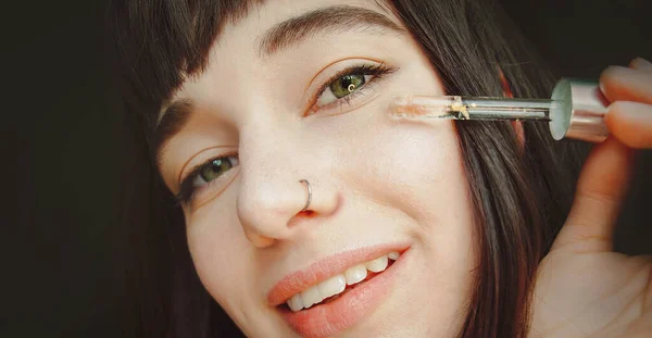 Sebuah Brunette Menarik Dengan Menusuk Hidung Berlaku Serum Wajahnya — Stok Foto