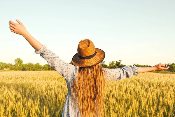 stock image Woman with long blond hair and a straw hat in a wheat field.