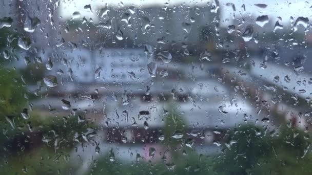 街で雨が降った 水がガラスに落ちて 雨が降って 逃げる 夏の雨の中 大きな雨が窓ガラスに当たりました — ストック動画