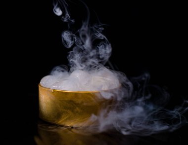 Dumanlı altın bir kutuda buz, renkli duman, mavi duman, gri duman, şerbetli buz, lezzetli buz. Koyu arkaplanda boşluk resmi