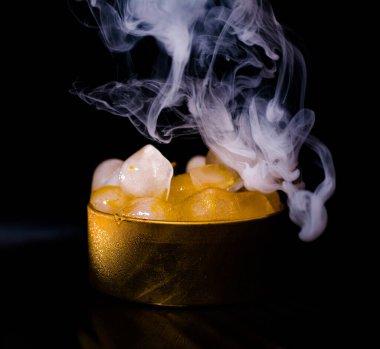 Dumanlı altın bir kutuda buz, renkli duman, mavi duman, gri duman, şerbetli buz, lezzetli buz. Koyu arkaplanda boşluk resmi