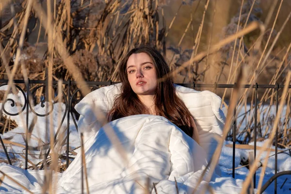 stock image seductive, young, sexy, woman, in white underwear, lingerie in bed in a dreamy snowy winter landscape between reeds, copy space