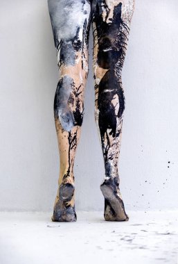 back view to beautiful legs and feet on tiptoe of a sexy young artistically abstract painted woman, ballerina with black and white, paint, from behind, creative bodypainting, copy space.