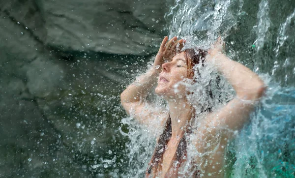 美人若い可愛い色気の赤毛の女が温泉ウェルネスで滝の水しぶきをリラックスし 滝の水を感じ スペースをコピー — ストック写真