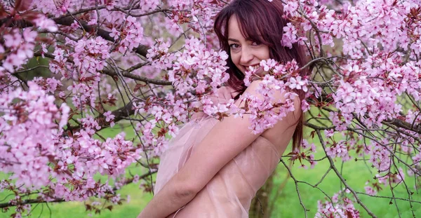 桜の間の開花庭で若い幸せな笑いの女の子の愛の春の肯定的な感情 コピースペース — ストック写真