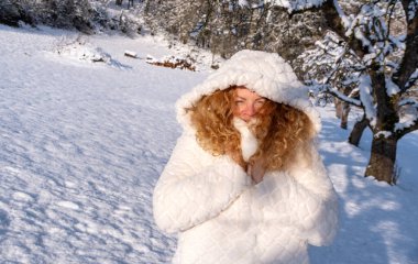 Güzel, seksi, baştan çıkarıcı, kızıl saçlı kızıl saçlı, kızıl saçlı, güzel bir kızın portresi. Soğuk kış doğasında mutlu, beyaz önlüklü ve kapşonlu.