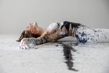 Siyah beyaz renkli seksi çıplak kadın, beyaz, siyah, gri stüdyo zemininde dekoratif bir şekilde yatıyor. Yaratıcı, soyut vücut boyama sanatı, kopyalama alanı