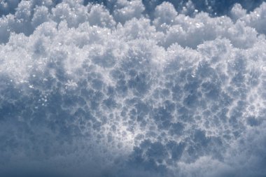 Narin buz kristallerinin büyüleyici yakın çekimi ışıkta parıldıyor, buz desenlerinin karmaşık güzelliğini sakin, kış atmosferinde yakalıyor, uzayı kopyalıyor.