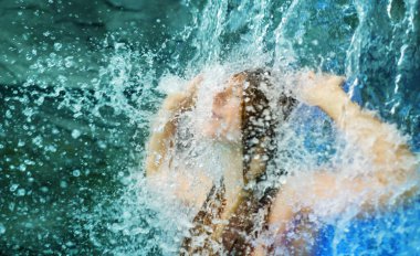 Işıl ışıl damlalarla kaplanmış, seksi, çıplak, kızıl kadın şelalenin altında duruyor, suyun ve duygunun vahşi yoğunluğuna dalmış. Bir özgürlük anı güzellik ve doğa ile bağlantı.