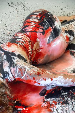 Kalın kırmızı, siyah ve gümüş renkle kaplanmış çıplak kadın vücudu yüzükoyun yere saçılmış bir yüzey üzerinde yatıyor, soyut vuruşlar ve canlı dokularla iç organik, anlamlı bir kompozisyonda birleşiyor..