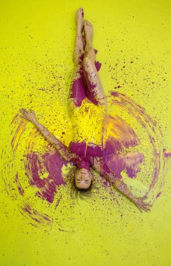 Bir kadın canlı sarı bir tuval üzerinde uzanır, vücudu koyu morla çizilmiştir. Boya etrafa ışık saçıyor. Güneş patlaması gibi. Hareketi ve rengi birleştirerek soyut ve cesur bir ifadeye dönüştürüyor..