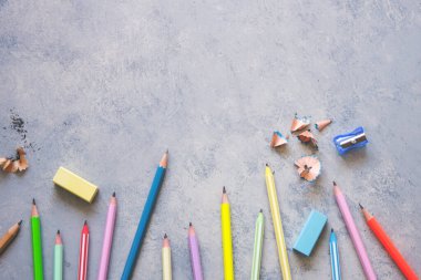 Gri arkaplanda kalem açacağı, silgi ve kalemler..