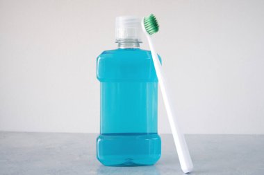 Masada bir şişe gargara ve plastik diş fırçası.