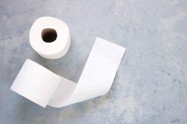 Gri arkaplanda tuvalet kağıdı rulosu