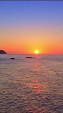 The sun is setting on the horizon, a beautiful vertical format video as a wallpaper for your iPhone