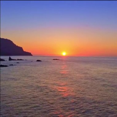 The sun is setting on the horizon, a beautiful vertical format video as a wallpaper for your iPhone