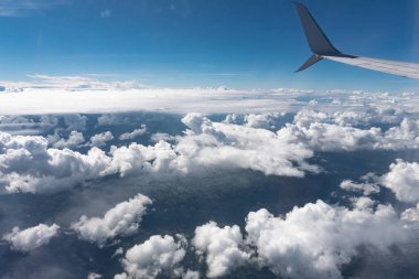 Clouds over the ocean passing under the wing of an airplane