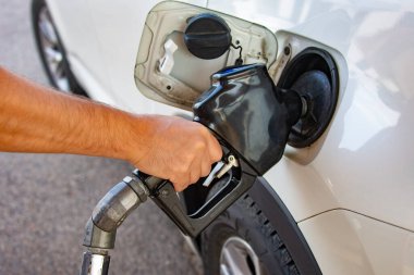 Yakıt ikmali için el ele tutuşan sürücü, arabayı çalıştırıyor.