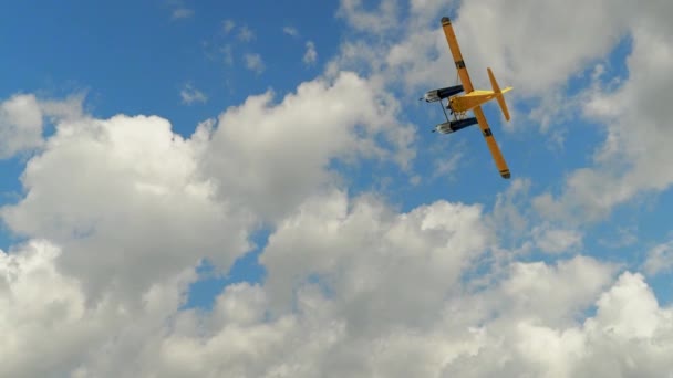 一架两座位的小型水上飞机在白云中飞往遥远的湖面 — 图库视频影像