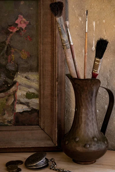 在一堵古墙的背景下 一幅画和一个用刷子作画的罐子 构成了一种静谧的生活 — 图库照片