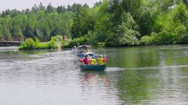Nehir teknesinde can yeleği giymiş bir aile.