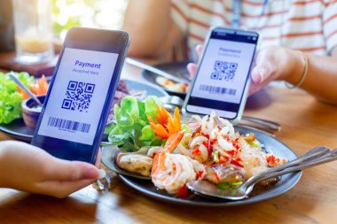 Bulanık Tayland yemeği ile etiketlenmiş QR kodunu taramak için akıllı telefona seçici odaklanma. Restorandaki müşteriler para almadan dijital ödeme yapıyorlar. Qr kod ödeme kavramı.