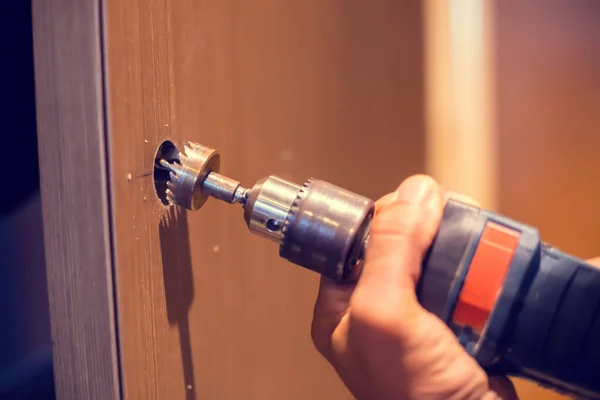 Drill holes in the door to install the digital door lock system.