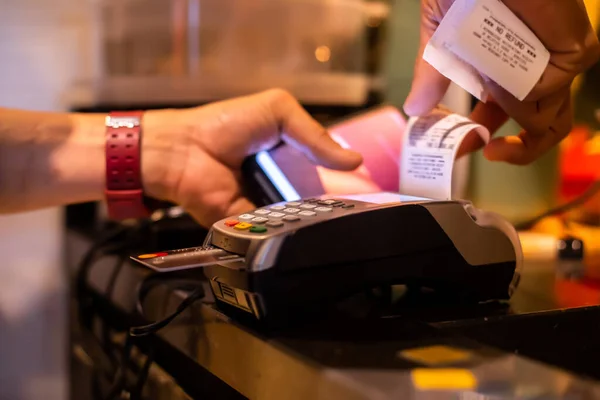 Selective focus to credit card reader with blurry hand pull slip for payment, buy and sell products or service , the concept of payment without cash.