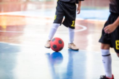 Futsal oynayan çocuğun bulanık görüntüsü şut ve gol için topu kontrol ediyor. Futsal spor geçmişi.