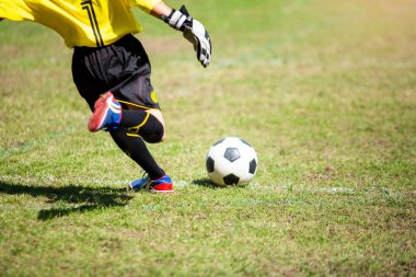 Çocuk kaleci çimlere serbest vuruş yapıyor..