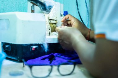 Optik bir mağazada gözlük lenslerini öğütmek ve budamak için makineye seçici odak.