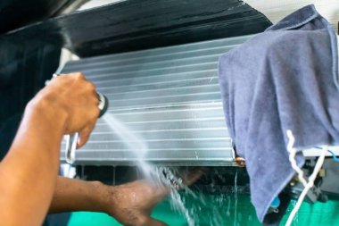 Yüksek basınçlı bulanık su spreyli soğutma bobini paneline seçici bir odak. Teknisyenden ev veya ofis temizliğine..