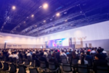 Bulanık iş adamı ve kadın toplantı başkanı ve yürütme komitesi geçmişinde hissedarlar toplantısı veya seminer etkinliği, yıllık hissedar toplantısı için toplantı salonunda oturuyorlar..