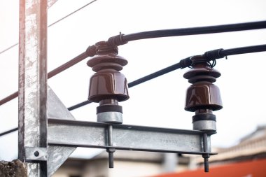 Elektrikli tel süspansiyon yalıtıcıları elektrik direğinde. Elektrik direğine bağlı elektrik kabloları olan yalıtkan yalıtıcıları gönder. Elektrik kulesi. 