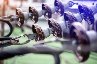 Elektrikli tel süspansiyon yalıtıcıları elektrik direğinde. Elektrik kablolarına elektrik direğine bağlı yalıtım cihazları yükle.