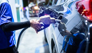 Benzin deposundaki arabayı elle doldurmak benzin istasyonundaki arabayı benzinle doldurmak benzin istasyonundaki yakıt deposunu doldurmak için seçici bir odak..