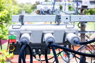 Tayland 'da elektrik kulesindeki yüksek voltaj kutusu. Elektrik kulesinde yüksek voltaj için uzaktan kumanda anahtarı ayarlandı ve kablolar bulanıklaştı.